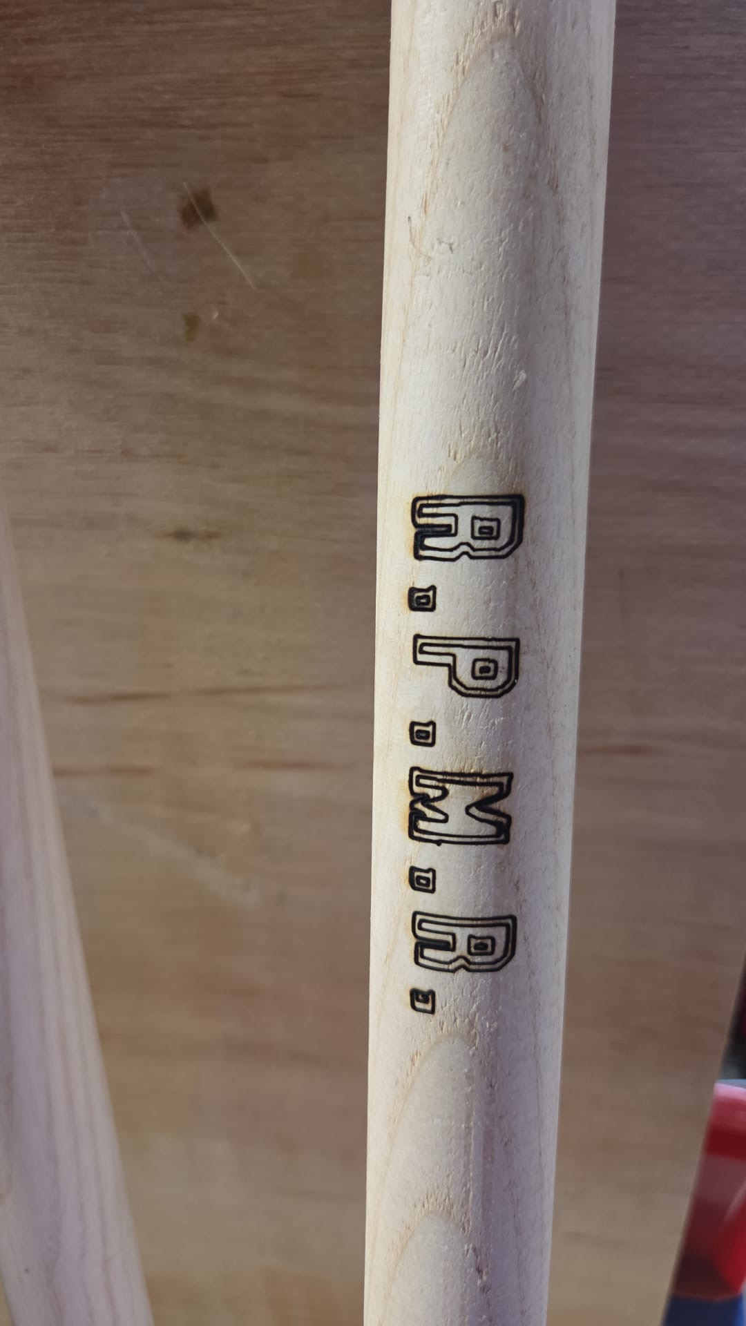 Houten gereedschapssteel met R.P.M.R. in het hout aangebracht